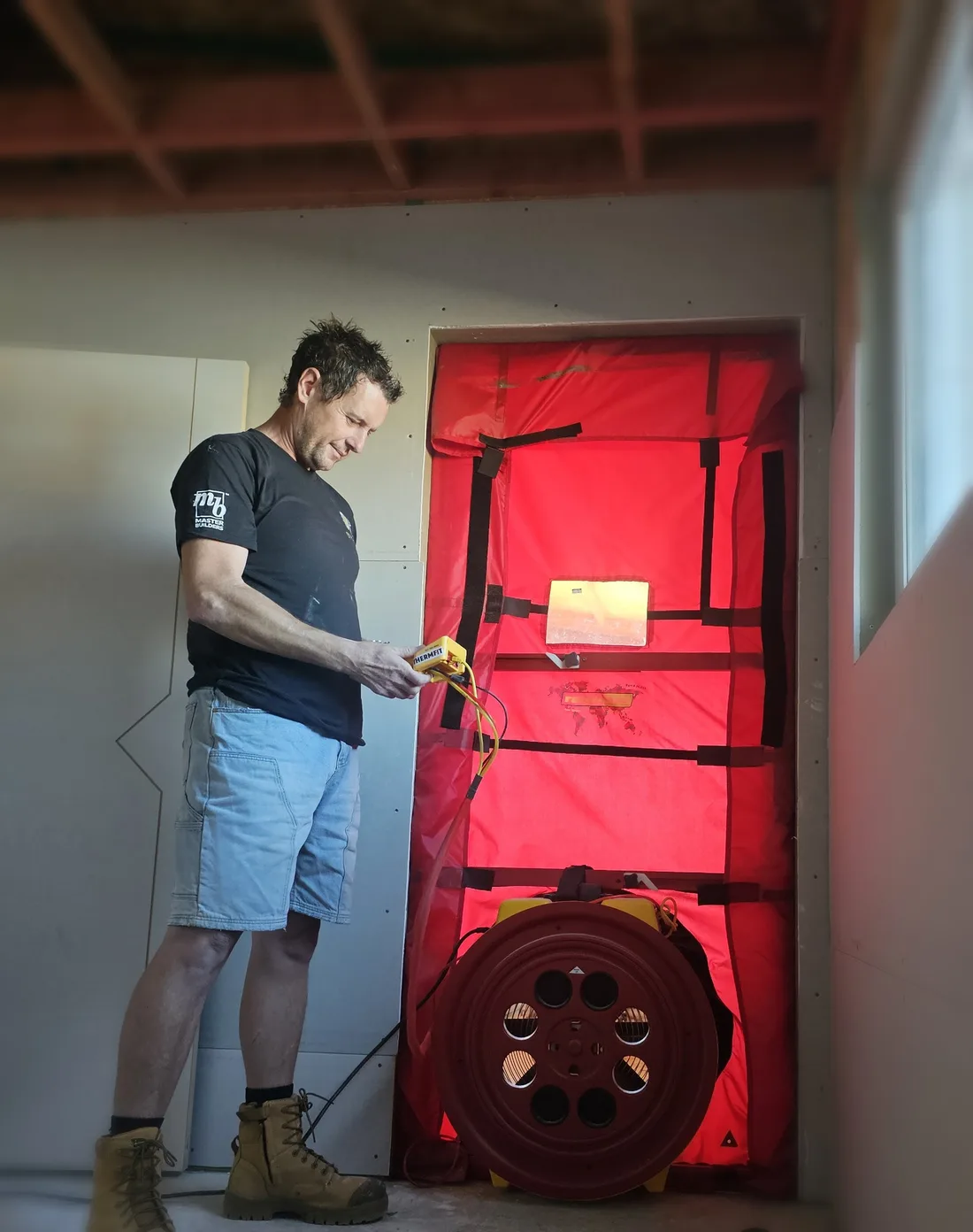 Daryl Combes running a blower-door airtightness test on site