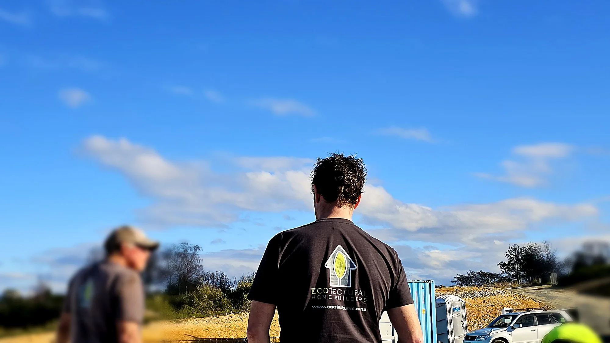 Ecotectural founder Daryl Combes on a slab-day build site, wearing an Ecotectural tee, Tasman