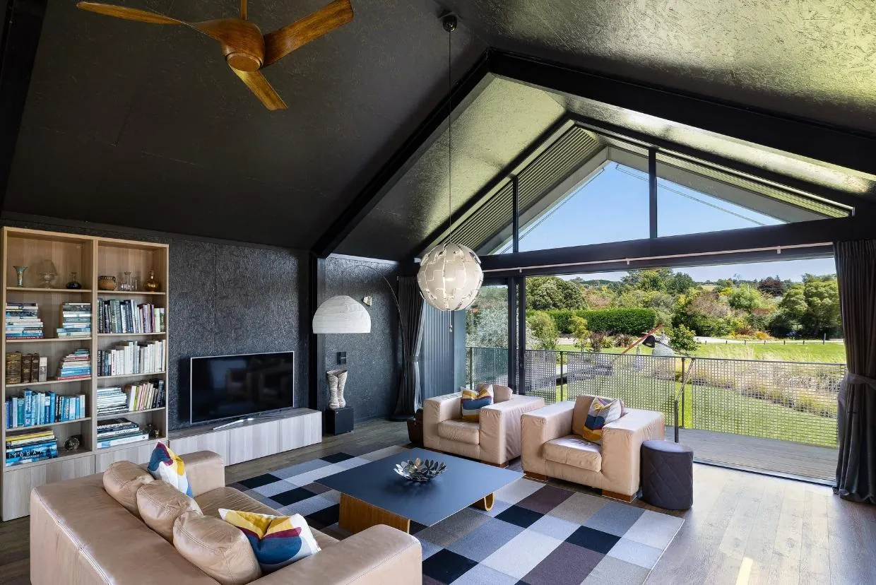Cathedral-ceilinged living space inside The Black House, Tasman