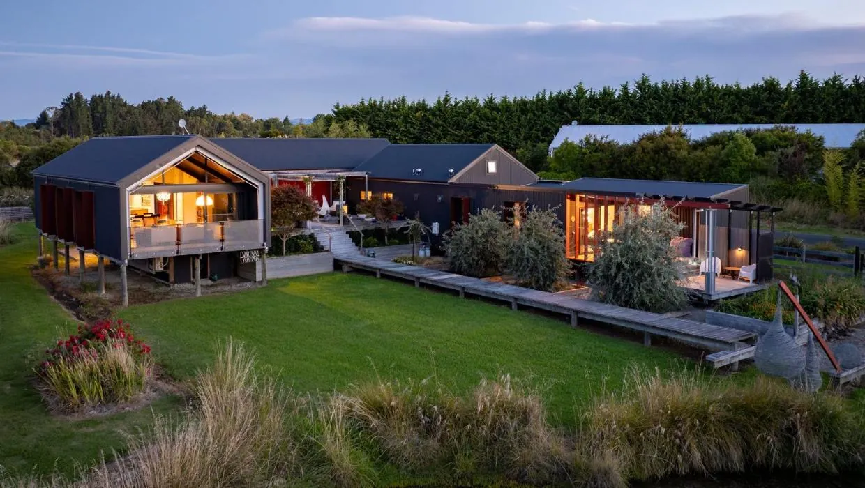 The Black House at twilight, a custom two-pavilion Ecotectural home featured on Grand Designs NZ