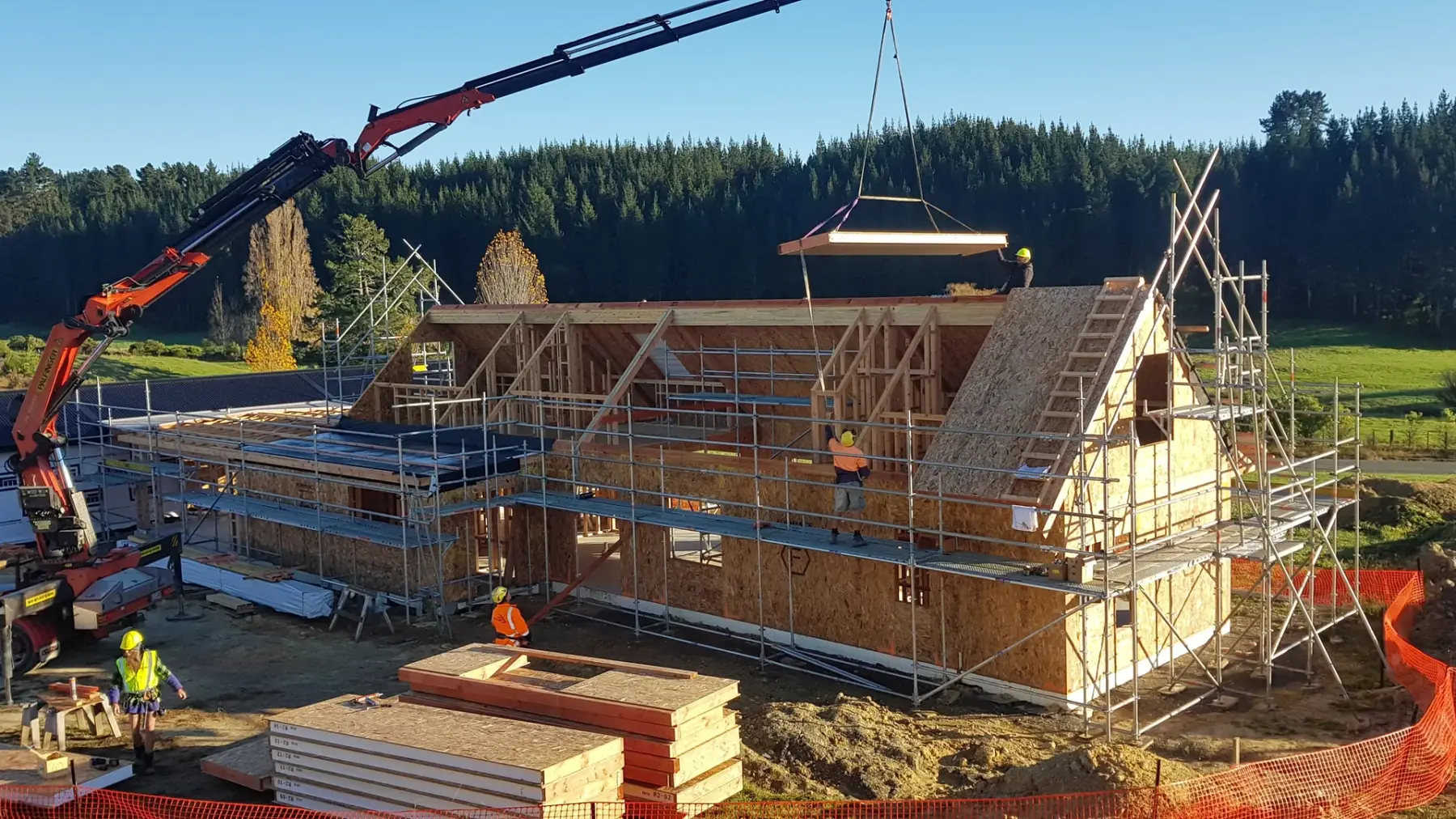 Crane lifting structural insulated panels into place on an Ecotectural site