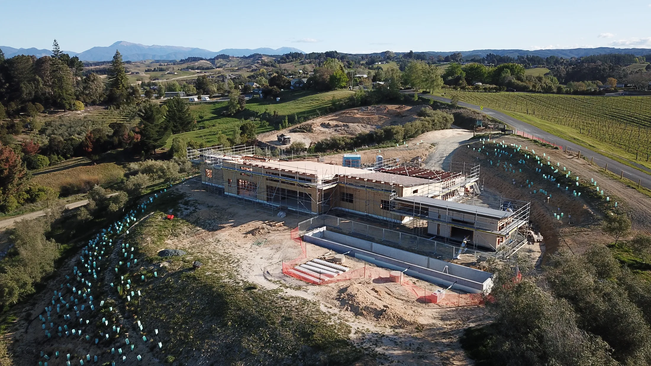 Aerial view of an Ecotectural SIP home under construction, Tasman, with mountains beyond