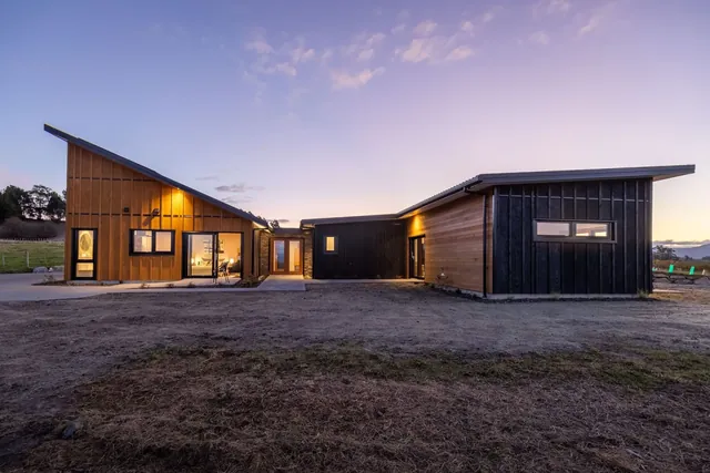 High-performance Ecotectural home at dusk at Horton Road, the Contact page hero