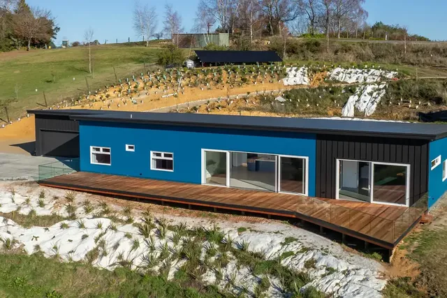 Aerial view of The Blue House and its long cedar deck, the Design and Build page hero