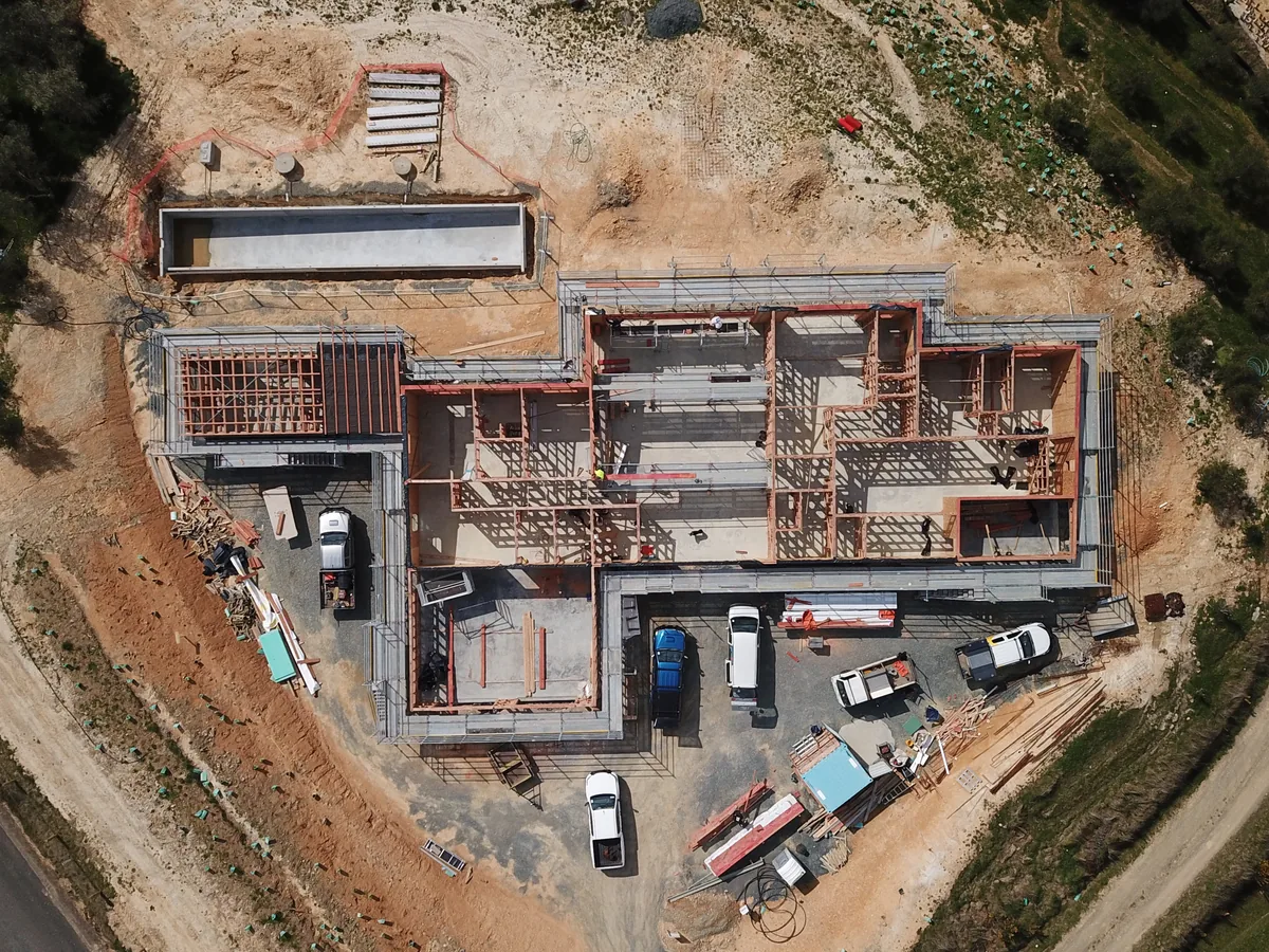 Aerial view of timber wall frames standing on the slab at an Ecotectural build