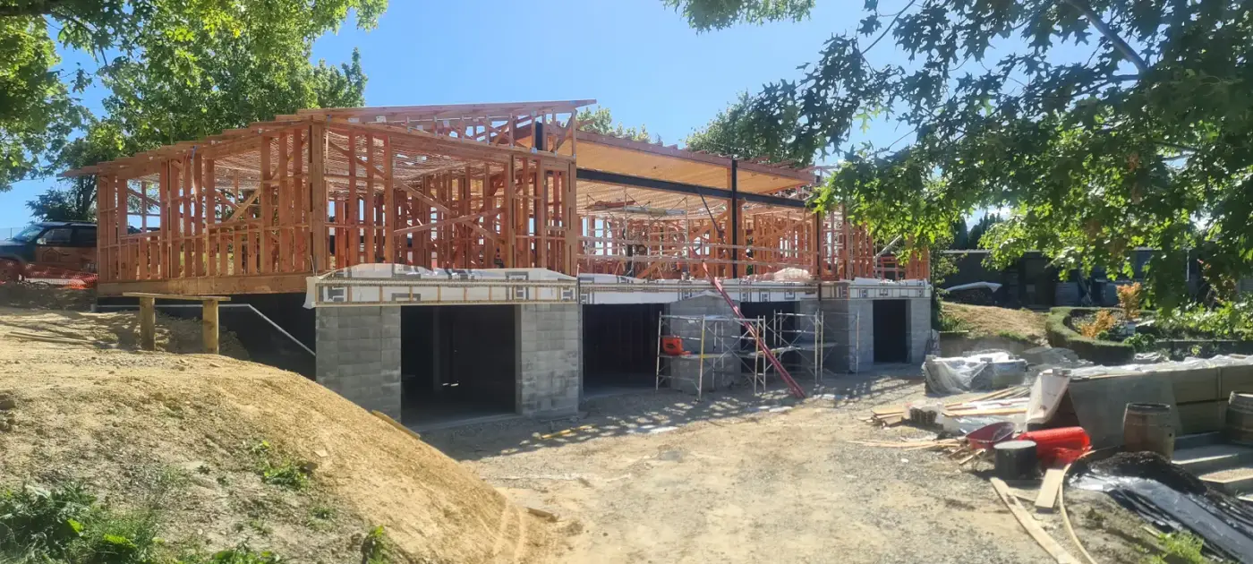Timber framing with exposed steel over the concrete-block lower level during the Pipin Lane build