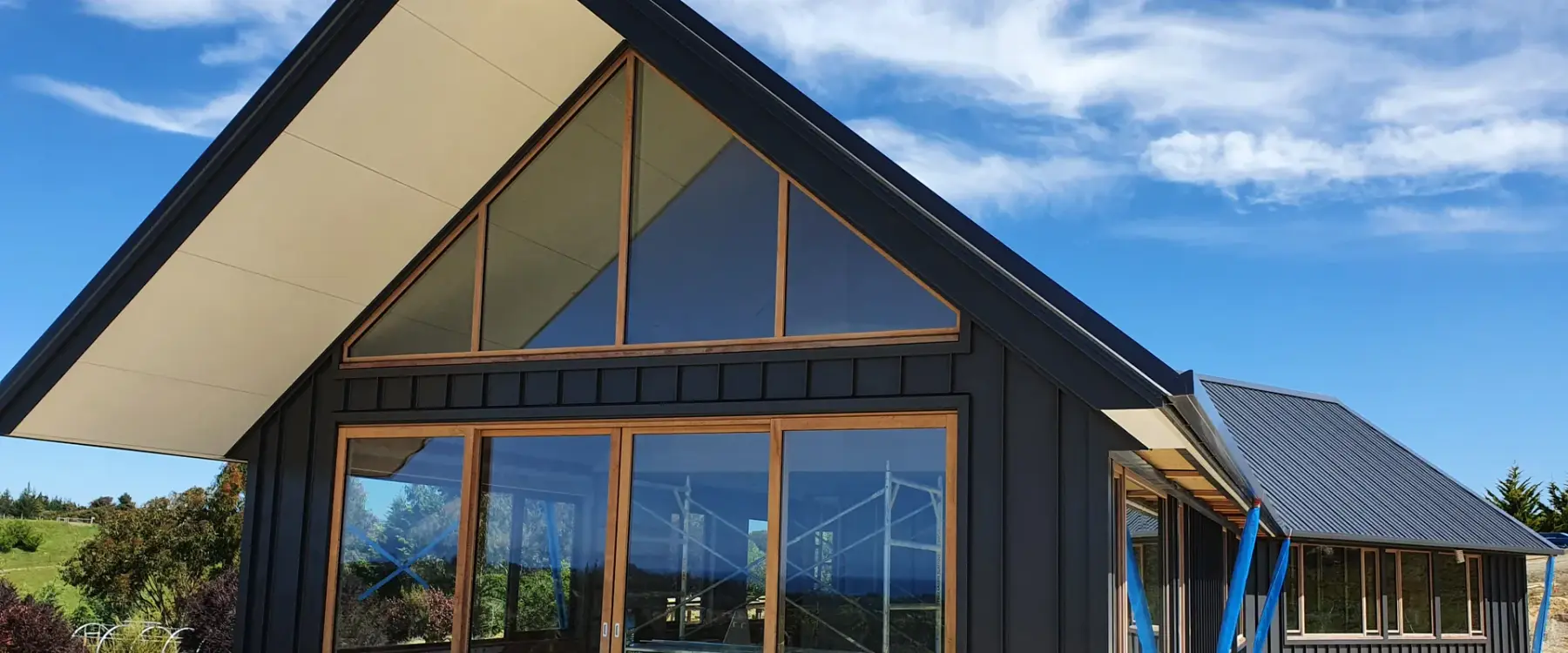 Black gable with full-height timber-framed glazing at Tasman View, during the build